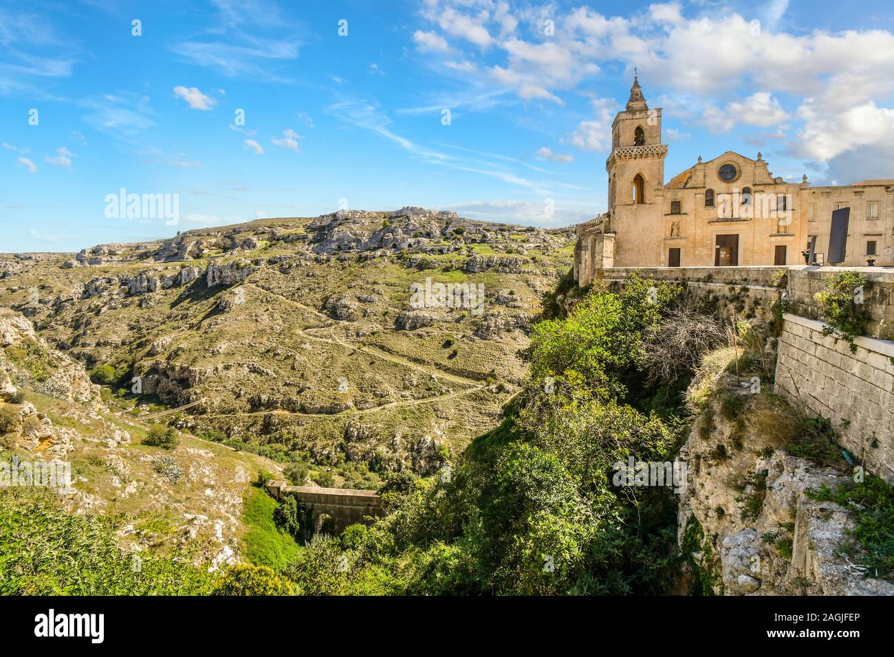 Des chemins à partir de l'ancienne coupe grottes sassi bas de la montagne et dans le canyon à Matera, Italie, comme l'église San Pietro le Dodici Lune est situé au sommet d'une falaise Banque D'Images