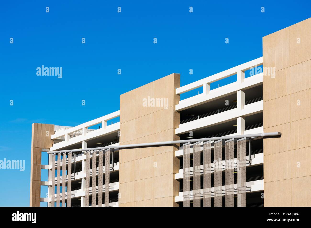 Vue extérieure du garage de stationnement multi niveaux typique sous façade bleu ciel. Banque D'Images