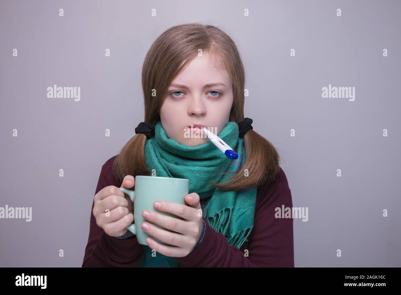 Jeune fille femme de race blanche avec le thermomètre l'air malade, fièvre, froid Banque D'Images