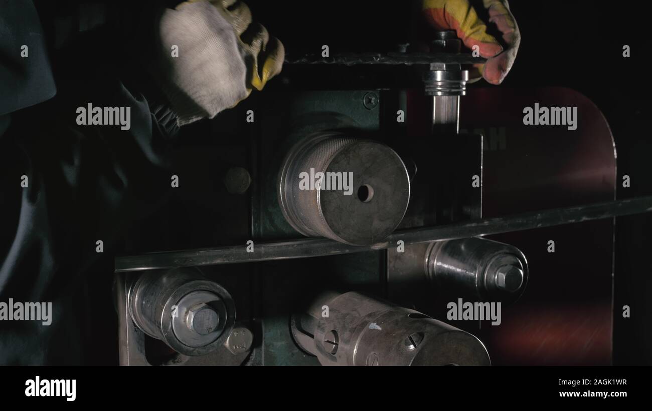 Aller de l'atelier sur la table. Coudes travailleur la tige de métal sur le pliage de la ronde en fer forgé. Fabrication d'un designer partie d'une tige métallique. Banque D'Images