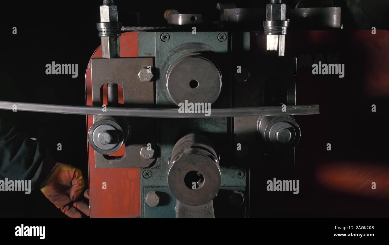 Aller de l'atelier sur la table. Coudes travailleur la tige de métal sur le pliage de la ronde en fer forgé. Fabrication d'un designer partie d'une tige métallique. Banque D'Images