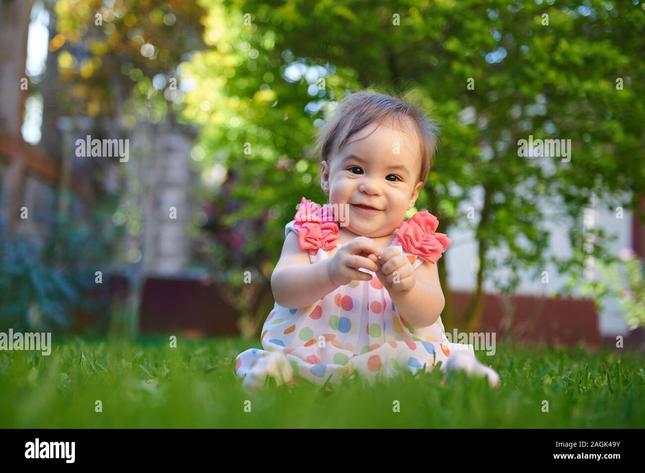 Cute baby girl portrait sur fond d'été brouillée Banque D'Images