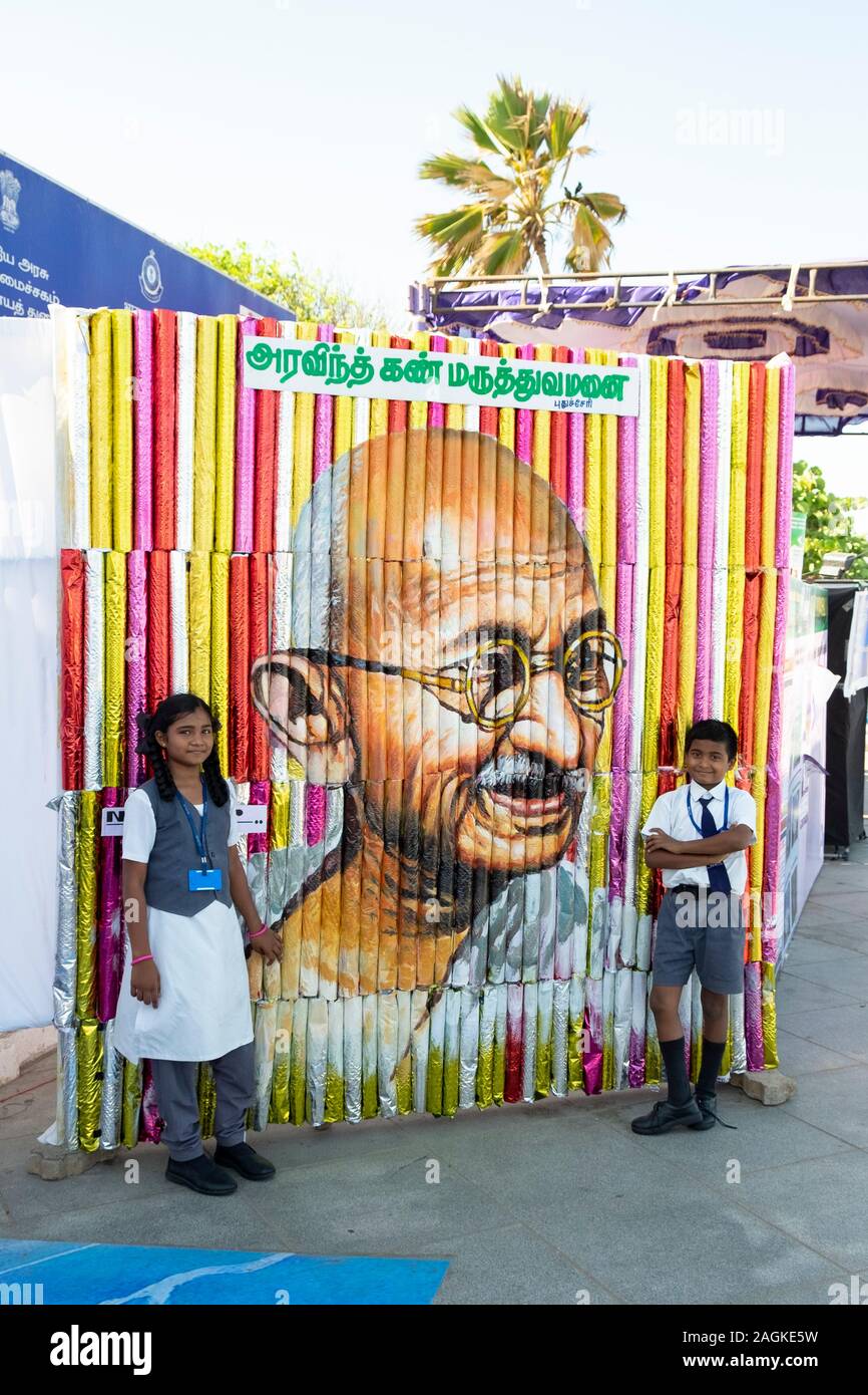 Lycéenne et school boy poser à côté d'un Ghandi portrait de Pondichéry, Tamil Nadu, Inde Banque D'Images