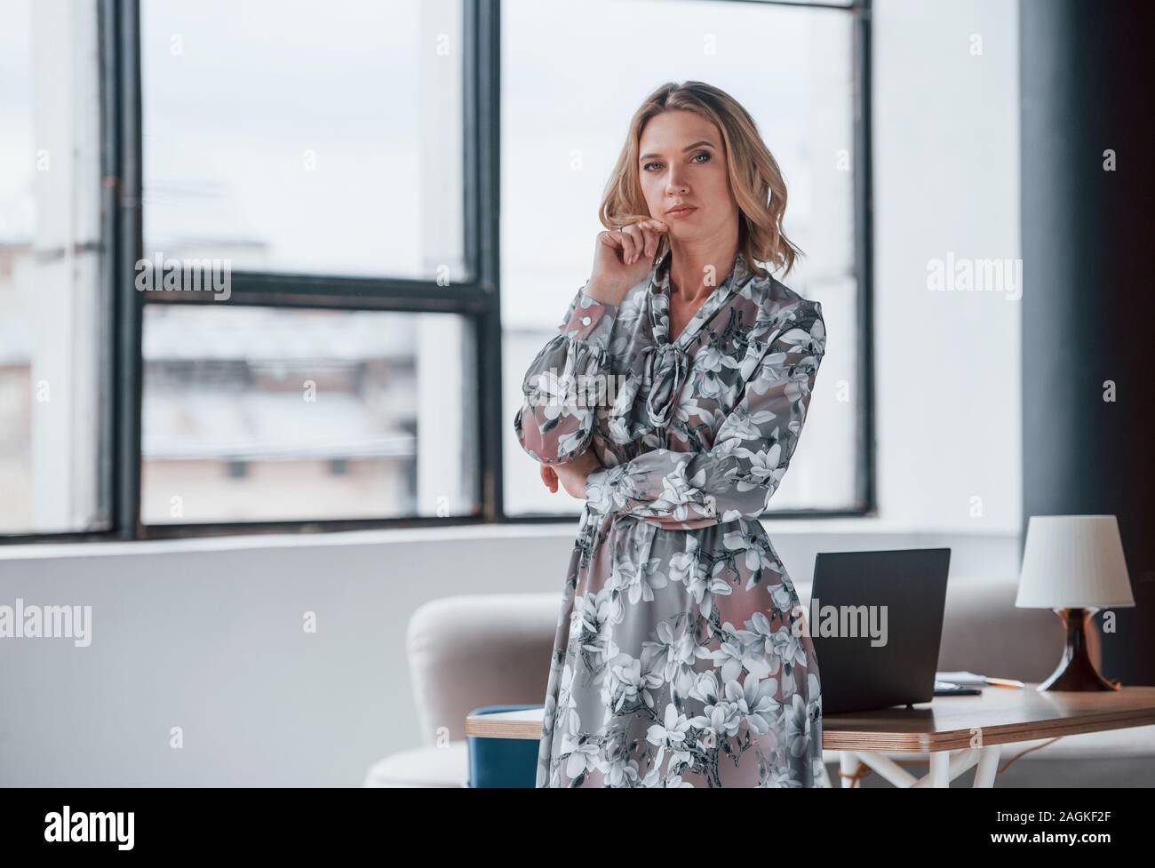 Bienvenue à family classe thérapeutique. Businesswoman avec cheveux blonds debout dans la fenêtre chambre contre Banque D'Images