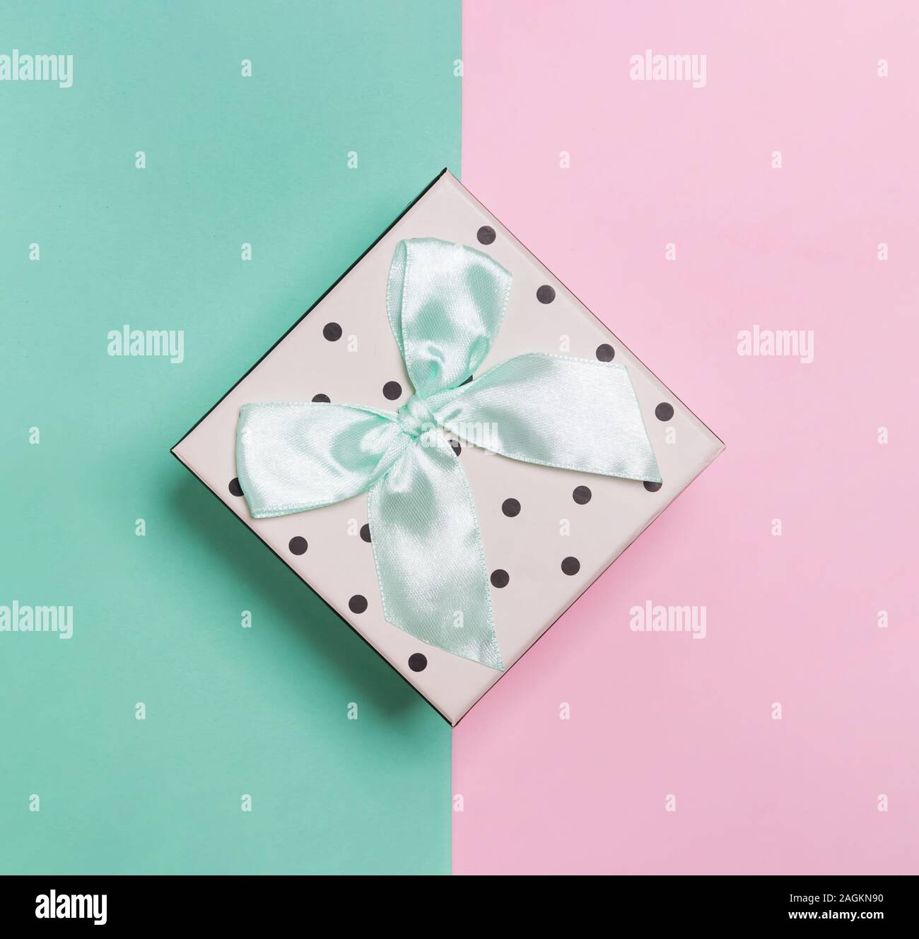 Petite boîte avec noeud sur l'arrière-plan de couleur pastel, Banque D'Images