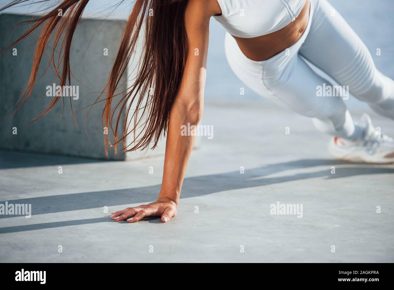 Photo de femme sportive faisant des exercices de remise en forme près du lac dans la journée. Banque D'Images