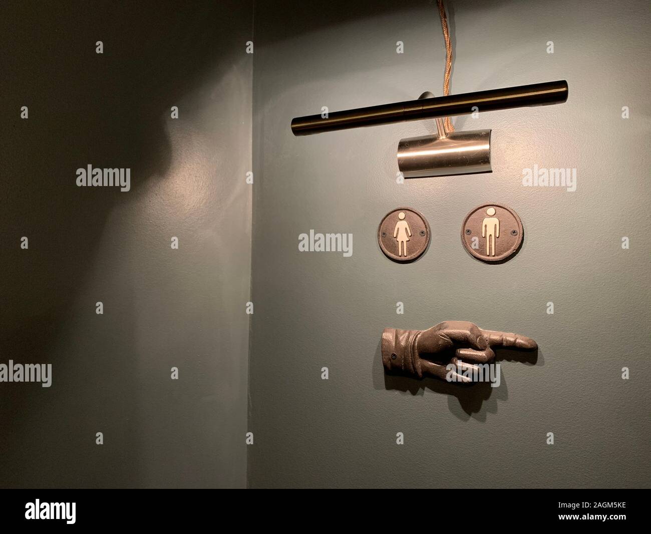 WC signe sur le mur gris d'une part orientée vers la droite et une lampe éclairant dans l'Europe de l'Lettonie Riga bar café restaurant Banque D'Images