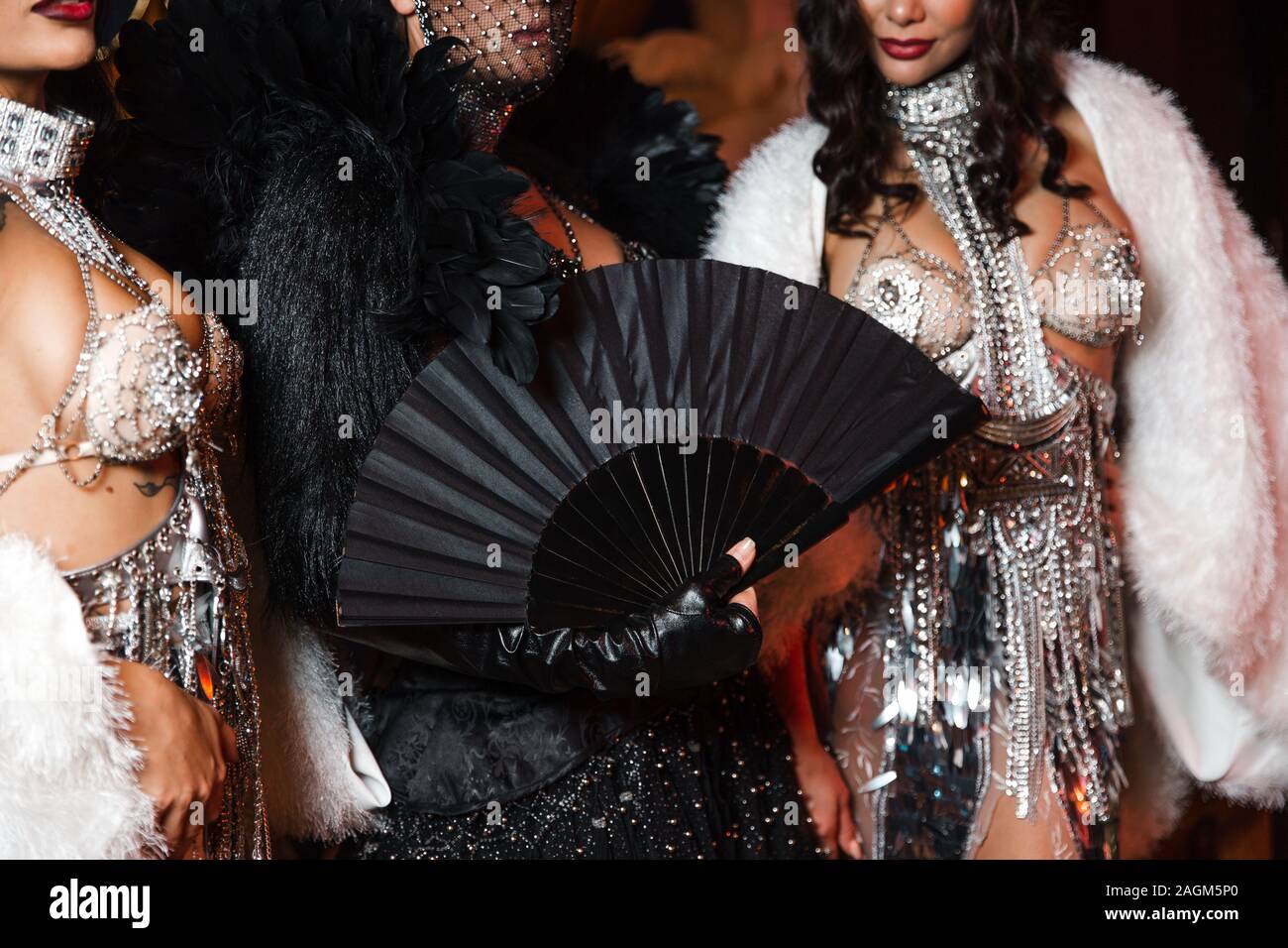 Show brillant avec Crazy Girls en cuir noir et blanc et plumes vêtements cristaux dans l'Europe de l'Lettonie Riga corporate event holding fan Banque D'Images