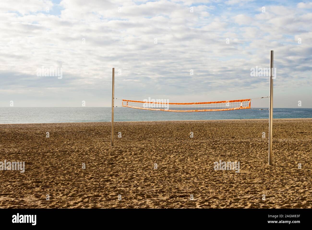Filet de volley-ball de plage dans une cour vide dans un jour nuageux le matin sur la côte. Banque D'Images
