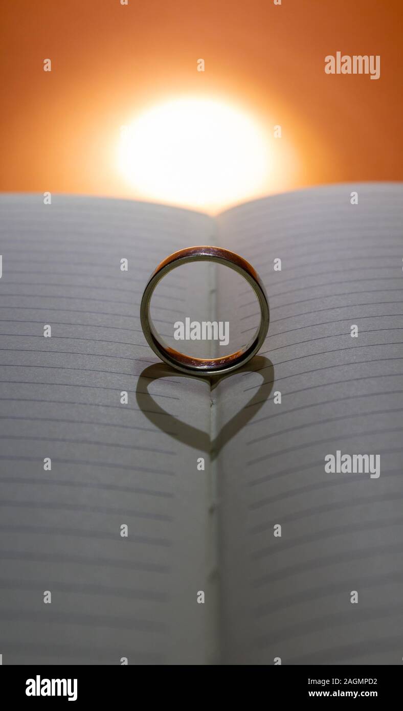 Forme un anneau de coeur sur un livre par le rétro-éclairage Banque D'Images