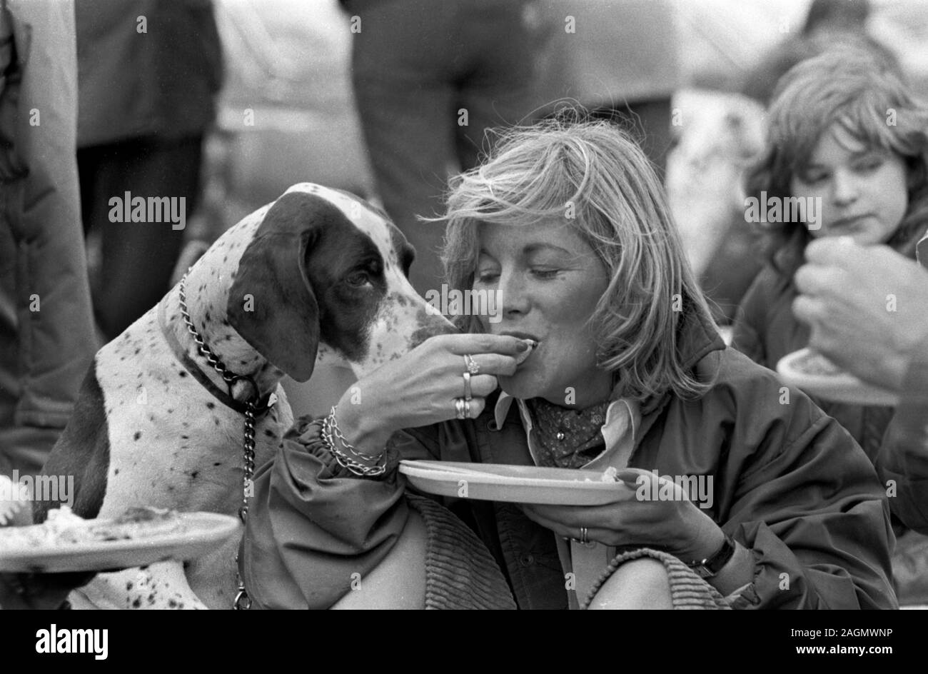 Les Britanniques adorent leurs chiens d'animaux. Chien reçu un régal par le propriétaire nourriture humaine étant partagée avec les animaux des années 1980. Personnes à Cowdray Park Polo Club 1981 UK HOMER SYKES Banque D'Images