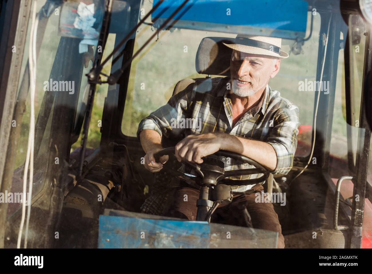 Portrait of smiling farmer autonomes tout en conduisant le tracteur Banque D'Images