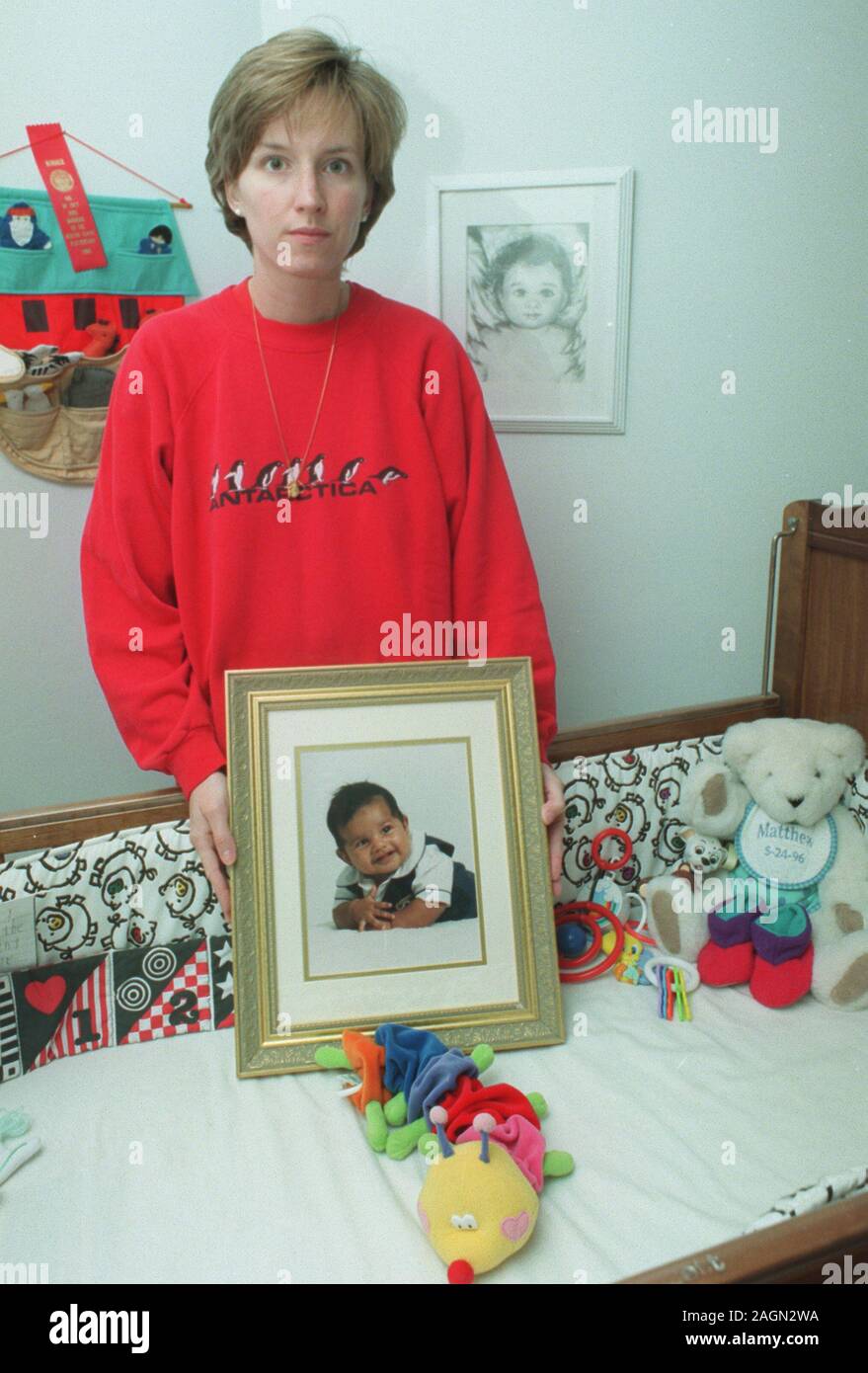 Deborah Eappen se trouve à côté de son fils mort Matthieu d'enfant tenant un portrait de lui dans sa chambre à coucher à leur domicile, à Newton, Ma Nov 1997. photo exclusive par Bill Belknap Banque D'Images