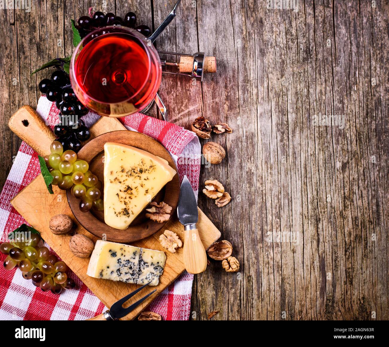 Vue de dessus de vin rouge, les raisins et le fromage sur la table rustique en bois avec fond copyspace. Une cuisine française de produit ci-dessus. Wine and Dine toujours la vie. Banque D'Images