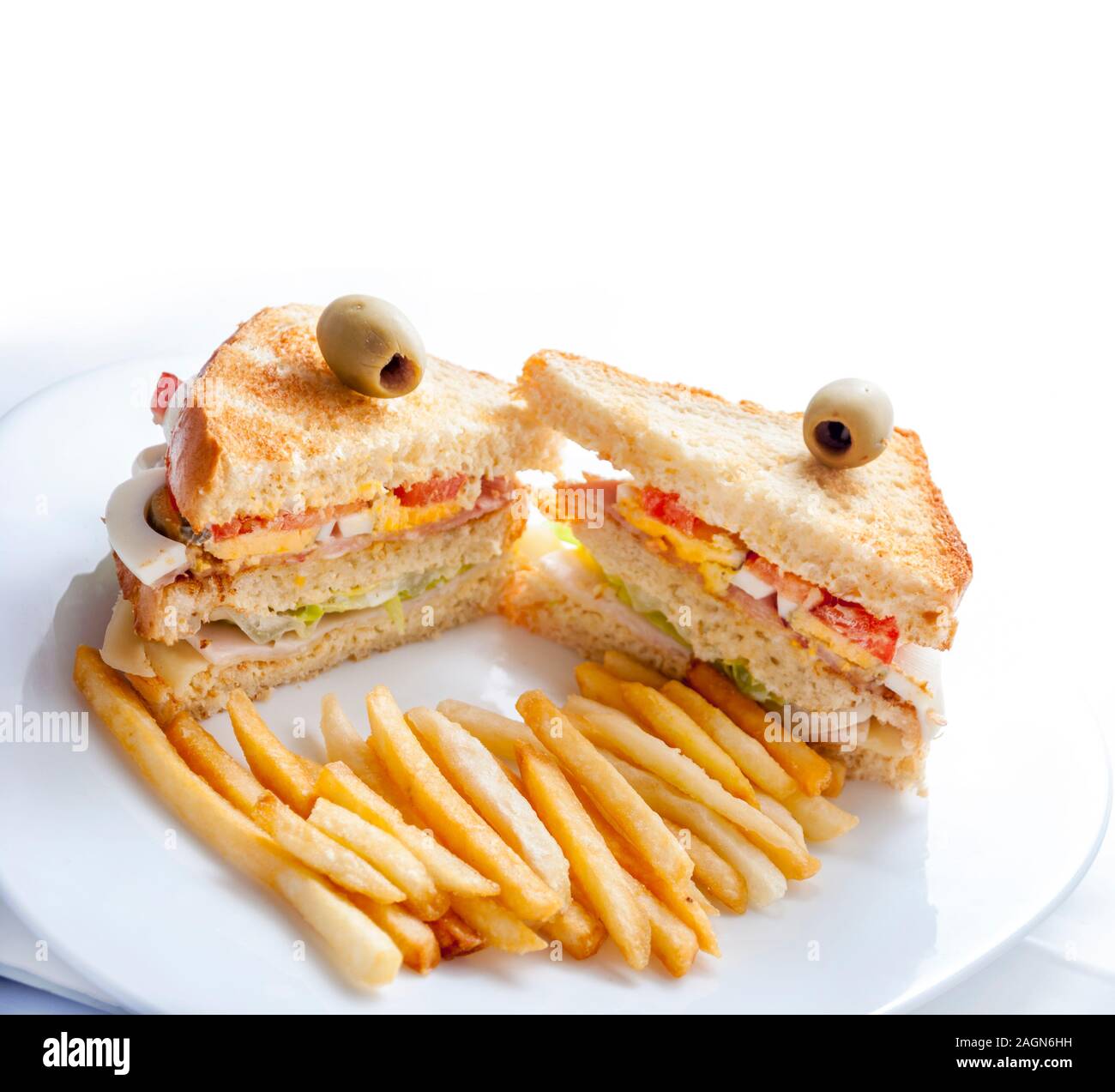 Gros-plan des sandwichs du club avec poulet, œufs, salade, pain grillé et frites servis sur une plaque blanche. Restaurant-snack-déjeuner sain isolé o Banque D'Images