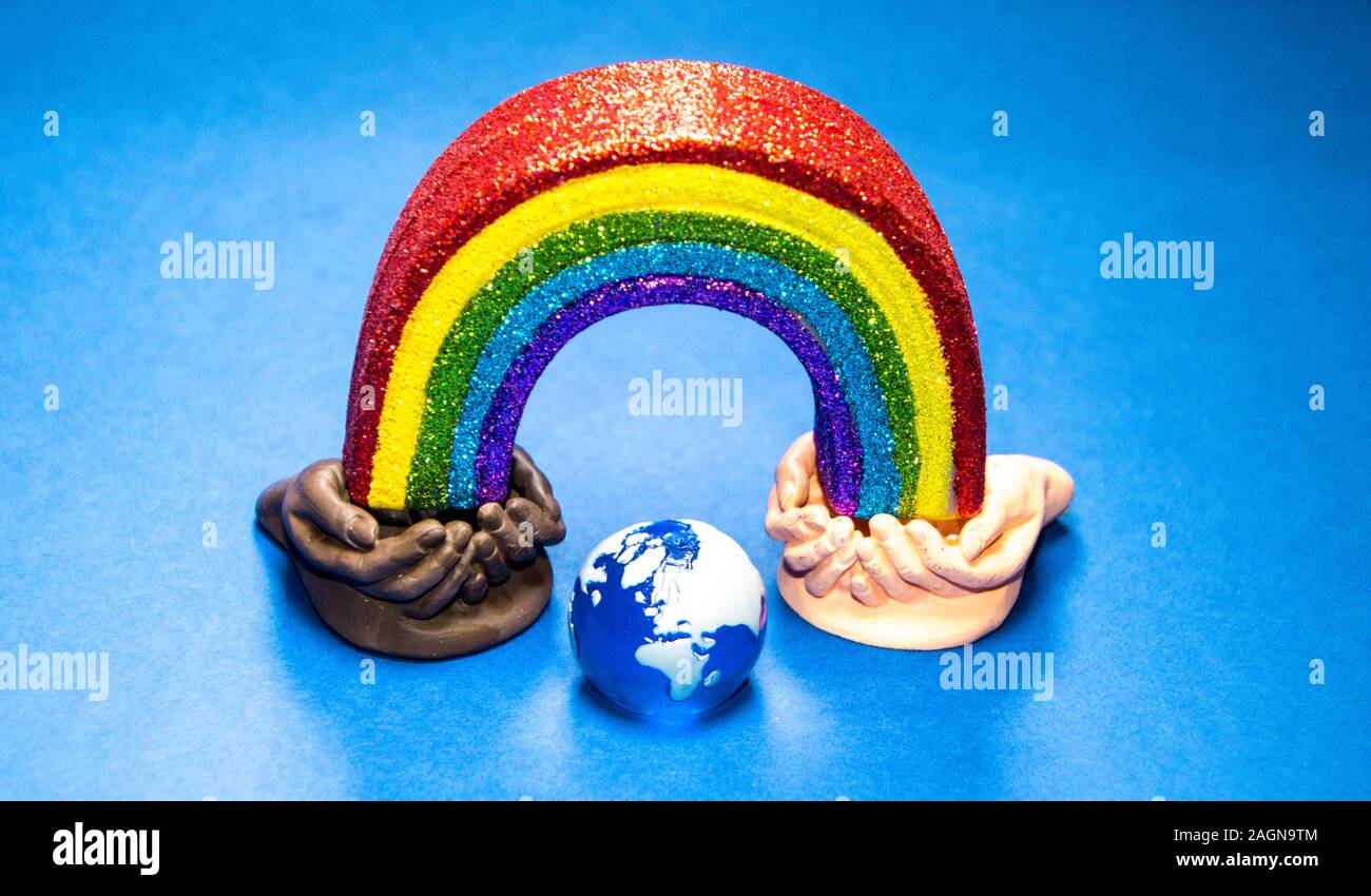 Deux ensembles de creux des mains, les deux races différentes, tenir chaque extrémité d'un arc-en-ciel. Banque D'Images