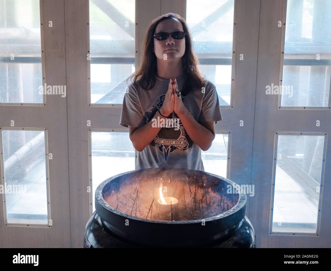 Un homme portant des lunettes de soleil japonais priant debout devant un  ciel priant avec une bougie allumée au Temple Kiyomizu-dera, Kyoto, Japon  Photo Stock - Alamy