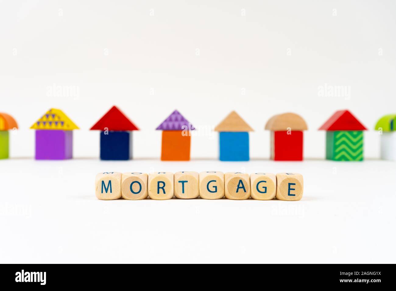 Bloc en bois avec des lettres pour dire 'M' hypothécaire en face de maisons colorées toy Banque D'Images