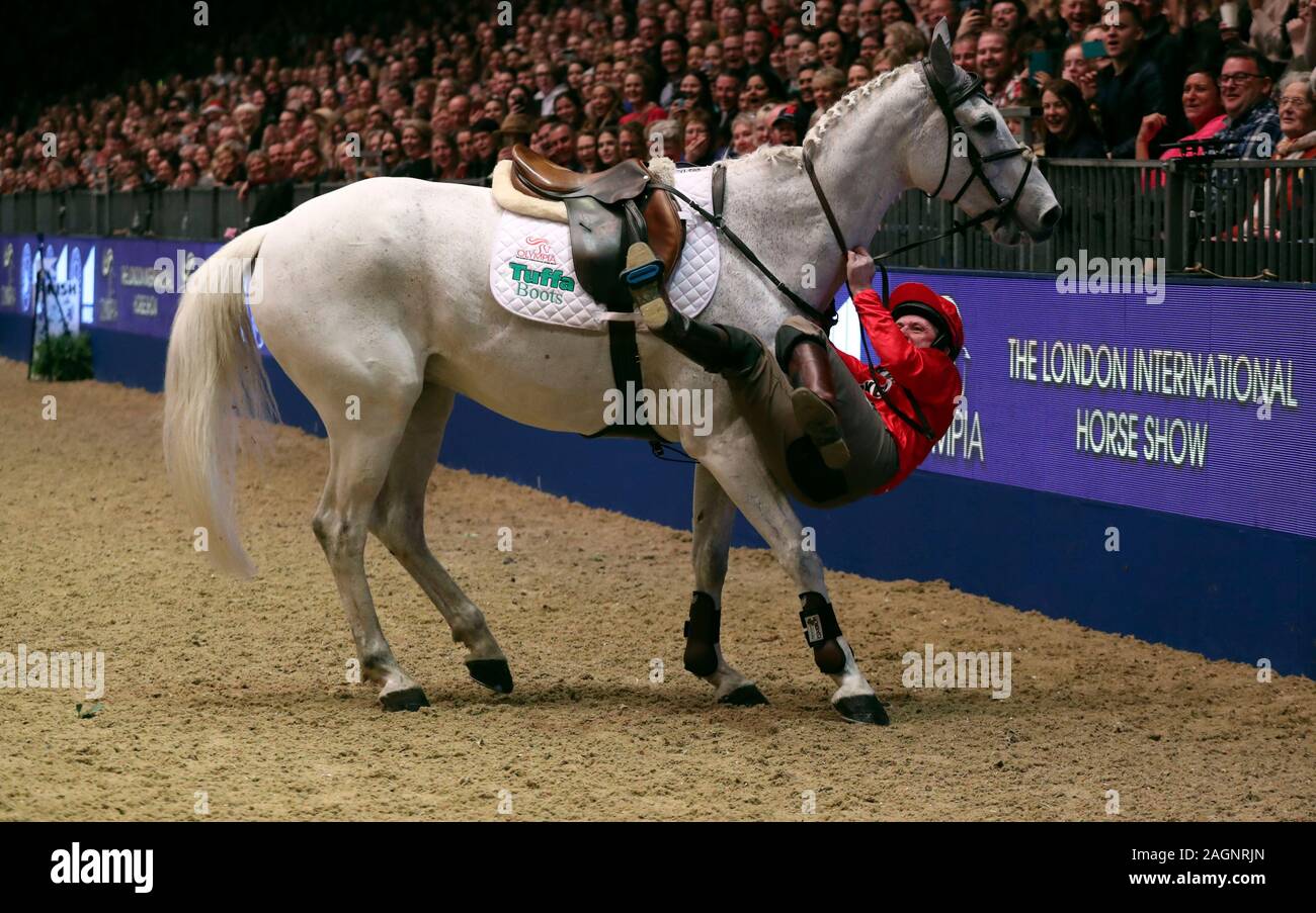 Sir Anthony McCoy tombe bien que concurrentes dans les jockeys Markel, saut à l'aide du Fonds au cours de la classe des jockeys blessés jour cinq de la London International Horse Show à l'Olympia de Londres. Banque D'Images