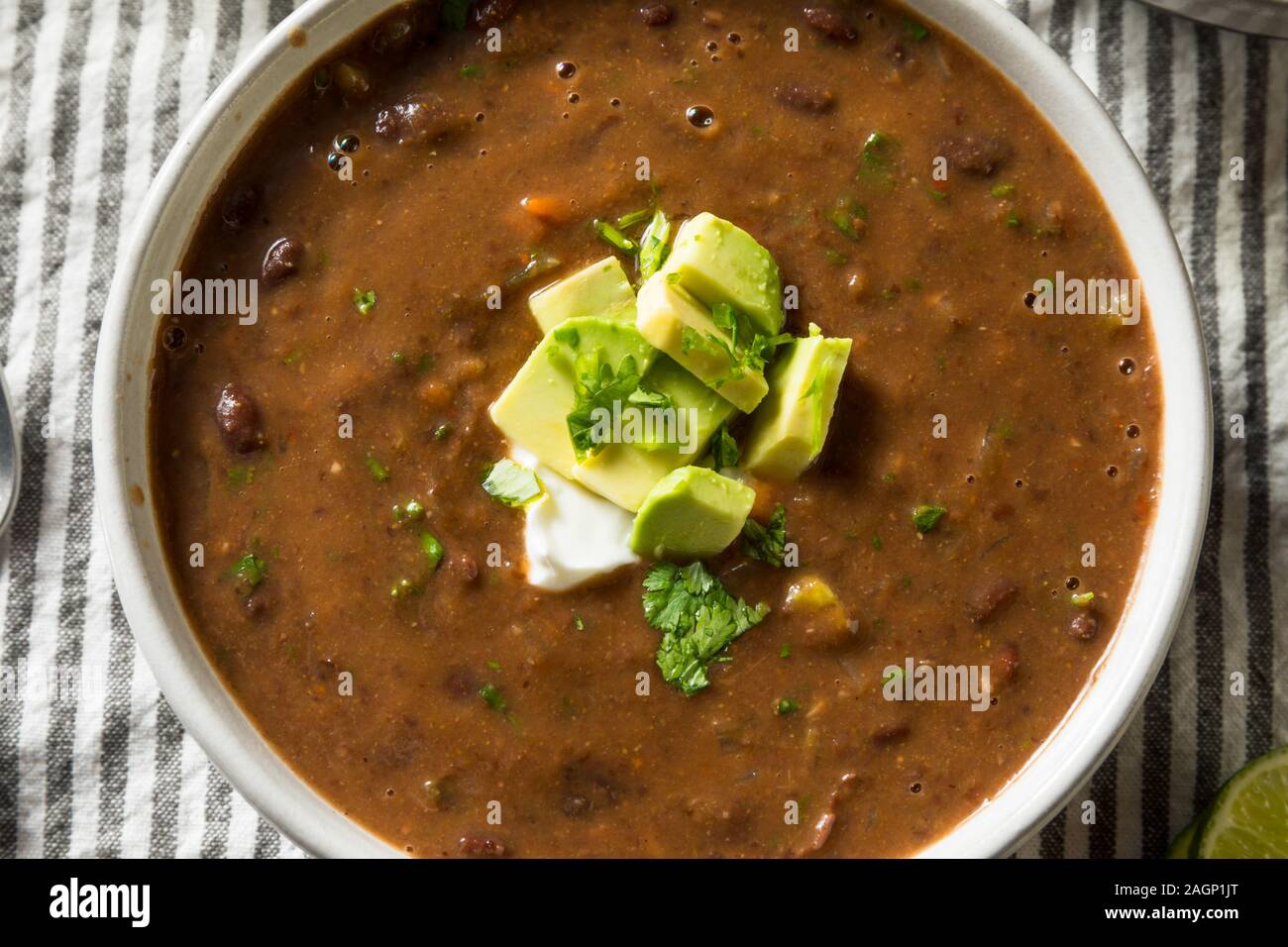 Soupe de haricots noirs Bio faits maison avec la coriandre et de l'avocat Banque D'Images