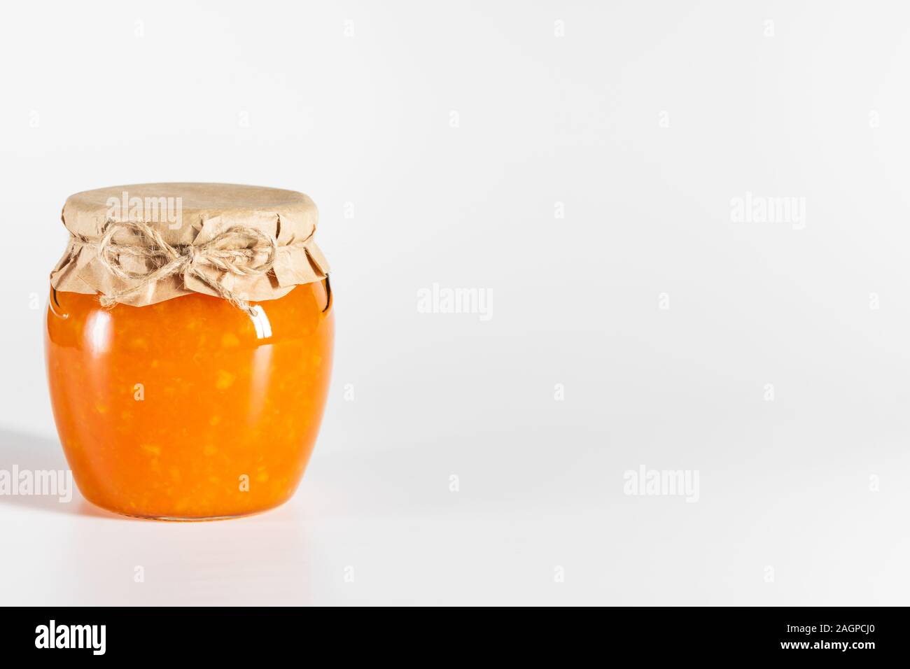 Juteuse de la confiture dans un bocal en verre sur un fond blanc. Vue de côté. Copier l'espace. Banque D'Images