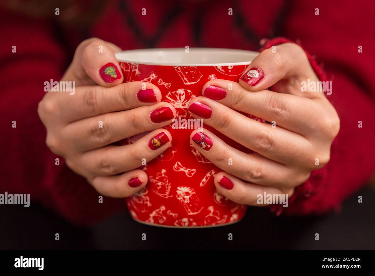 Woman's hand holding red une tasse de café. Avec une belle manucure d'hiver. Banque D'Images