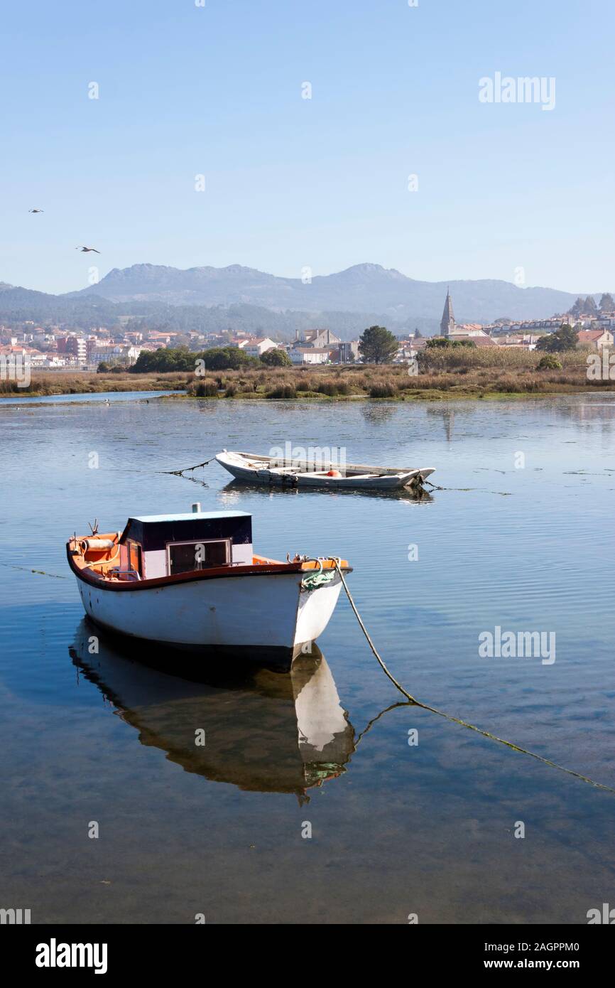 Vieux bateaux dans un marais Foz dans un Ramallosa, Vigo, Pontevedra, Galice. Sabaris Galineiro et de montagnes à l'arrière-plan. Banque D'Images