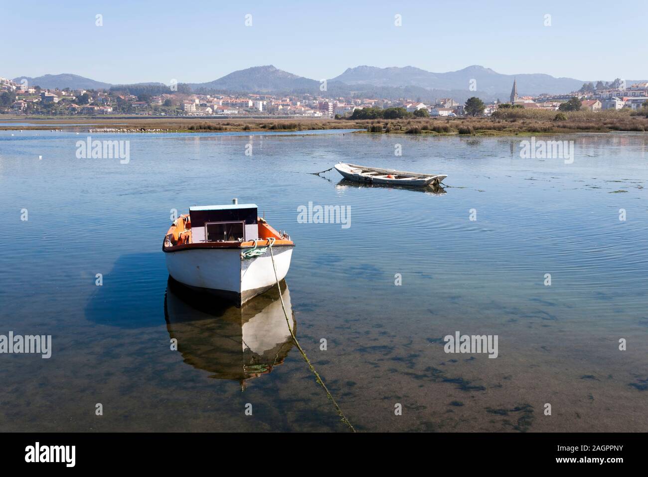 Vieux bateaux dans un marais Foz dans un Ramallosa, Vigo, Pontevedra, Galice. Sabaris Galineiro et de montagnes à l'arrière-plan. Banque D'Images