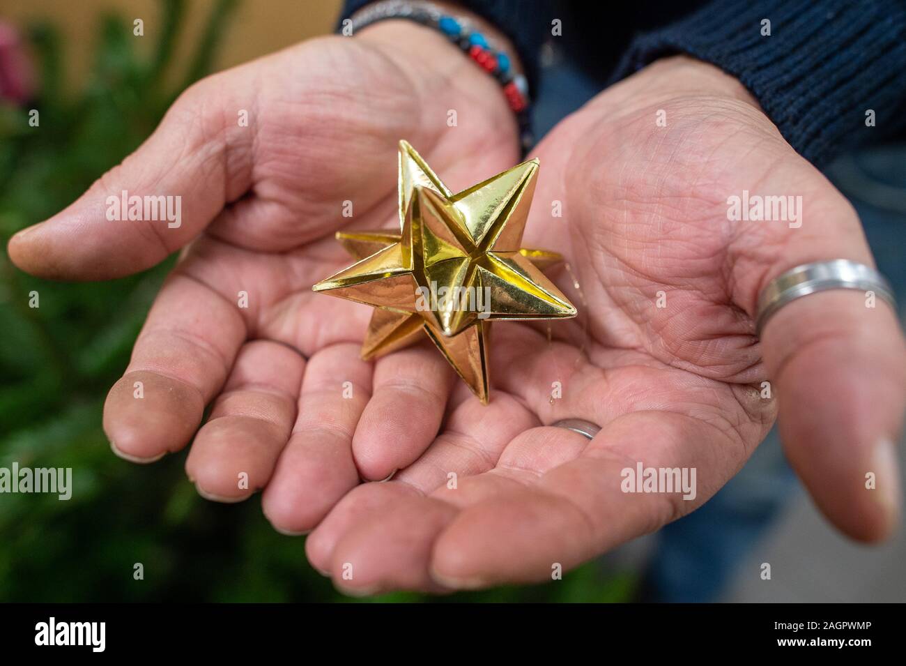 Magdeburg, Allemagne. Dec 19, 2019. Un visiteur de la mission de la station détient une étoile dans ses mains. Une petite fête de Noël aura lieu à la Mission de la Station le 24 décembre 2019, à laquelle tout le monde va recevoir un cadeau. Credit : Klaus-Dietmar Gabbert/dpa-Zentralbild/dpa/Alamy Live News Banque D'Images