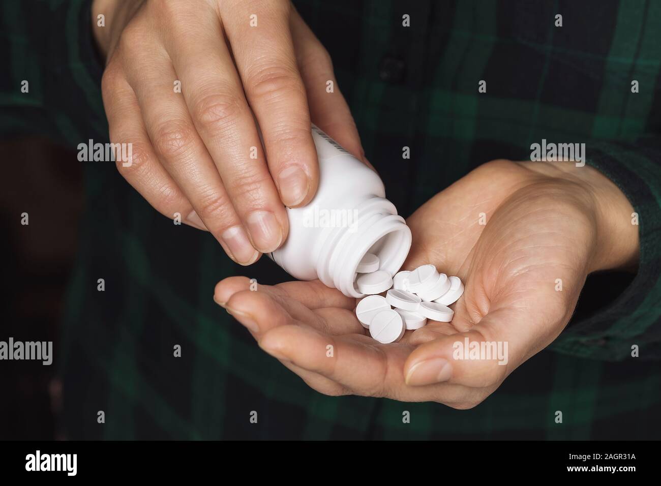 Un homme verse de comprimés dans la paume de sa main, close-up. Concept de médicaments Banque D'Images