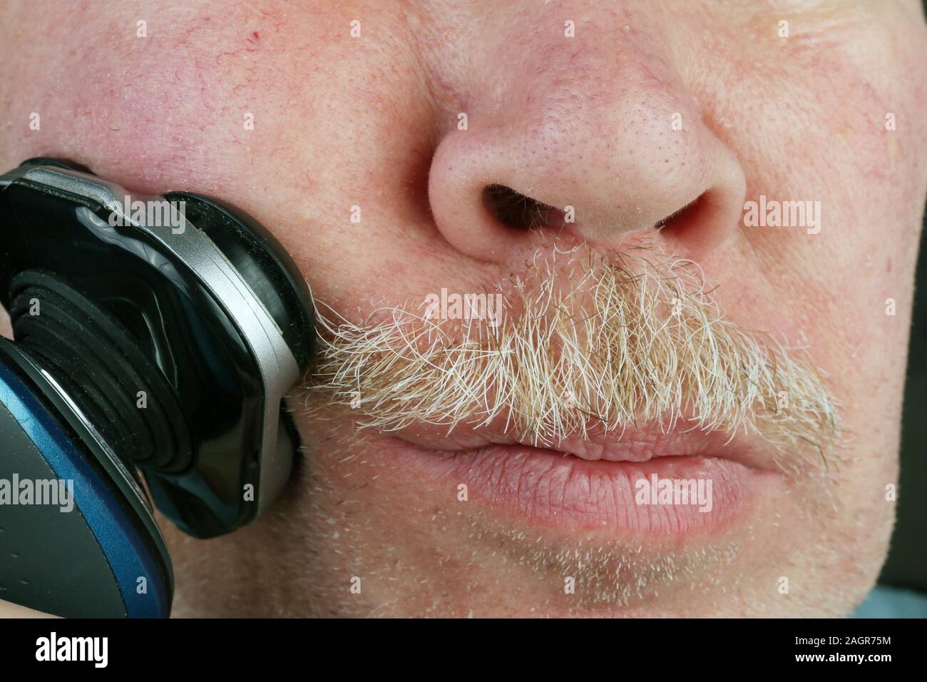 Personnes âgées vieil homme coupe cheveux sur son visage avec un rasoir  électrique. Couleurs naturelles macro Studio image simpliste Photo Stock -  Alamy