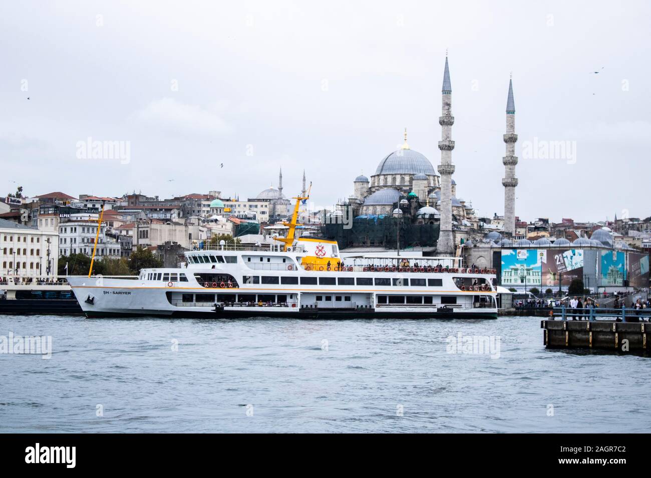 Istanbul, Turquie - Octobre-5.2019:La mosquée dans le district d'Eminonu et bateaux vente de poissons grillés. À gauche est une partie de le pont de Galata. Banque D'Images