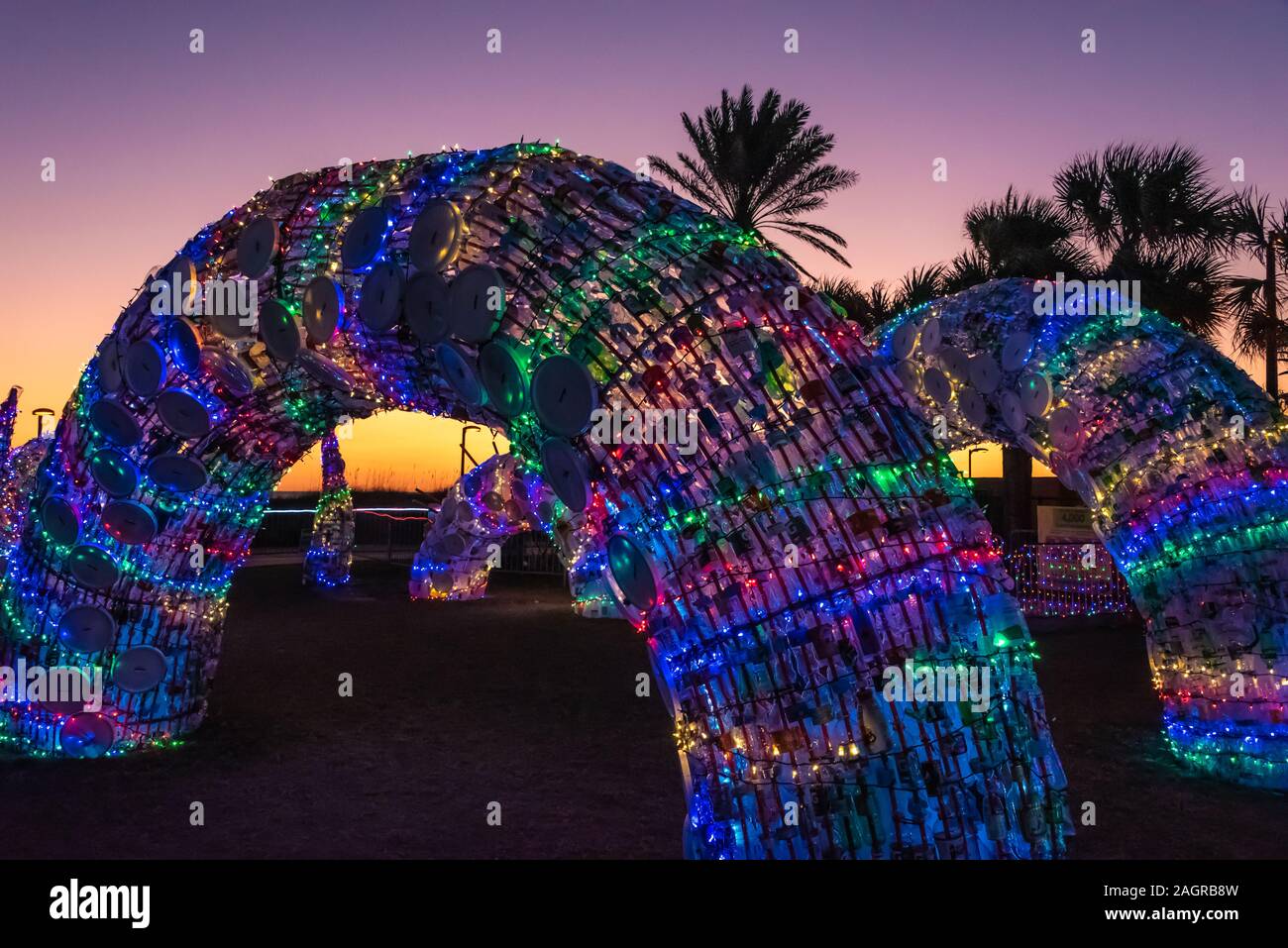 Serpent de mer de ses sculptures en bouteilles de plastique recyclées et lumières de Noël à Jacksonville Beach, Florida's 'DEck' les Présidents de l'événement d'art public. Banque D'Images