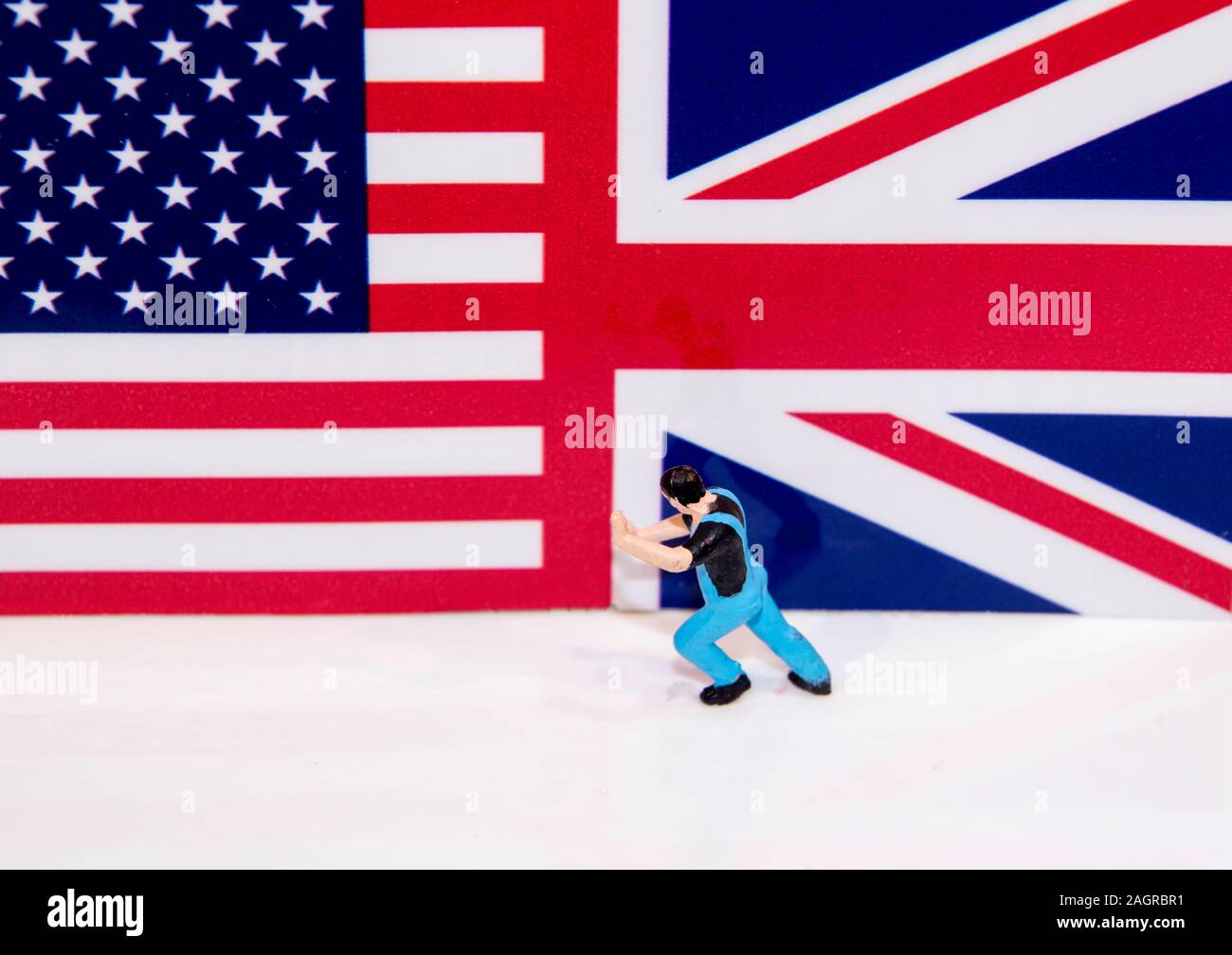 Un homme semble être repoussé le drapeau américain de l'être ensemble avec le Royaume-Uni, l'Union Jack flag. Banque D'Images