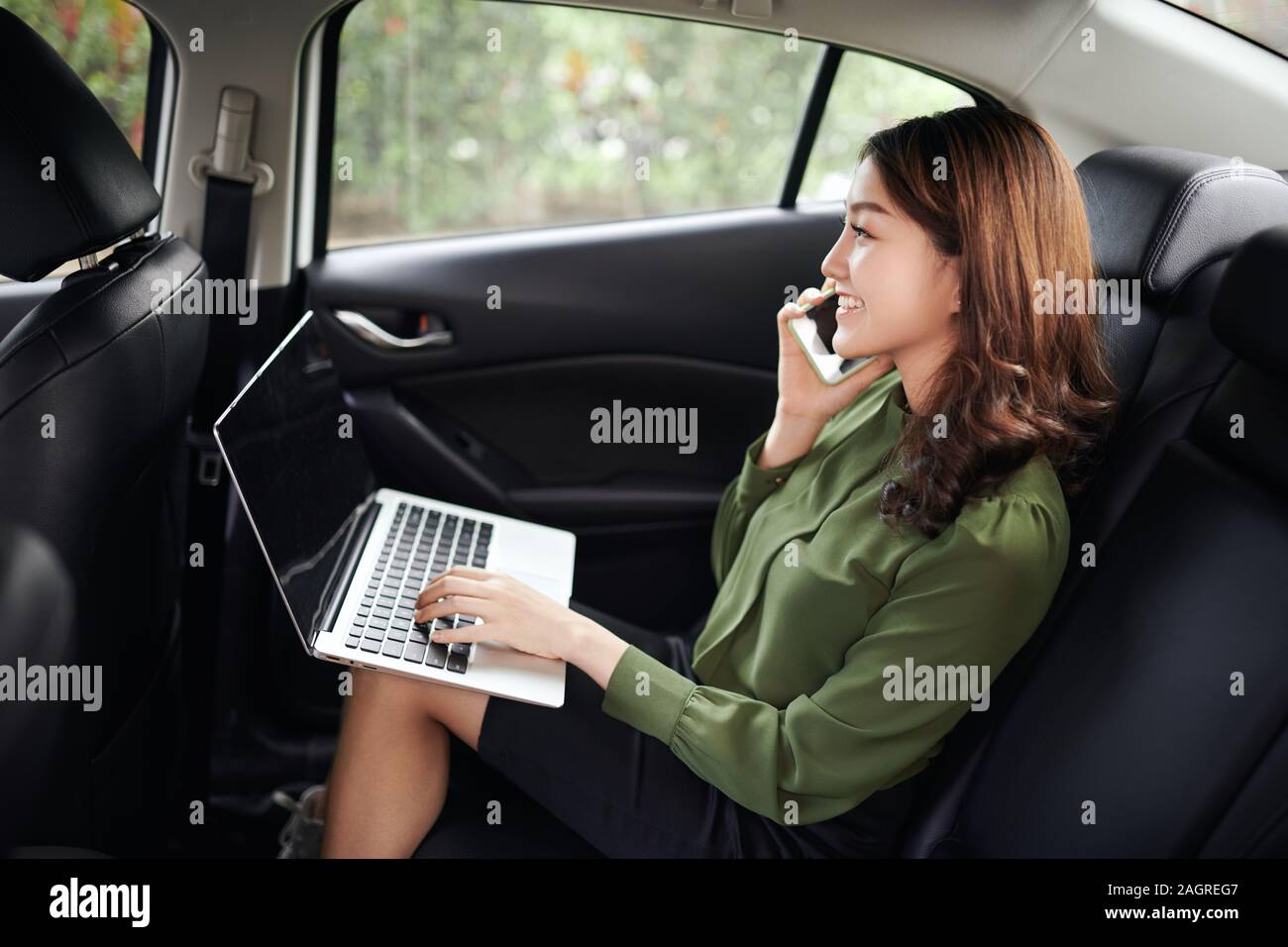 Femme d'exécutif de voitures de travailler sur son ordinateur portable. Banque D'Images