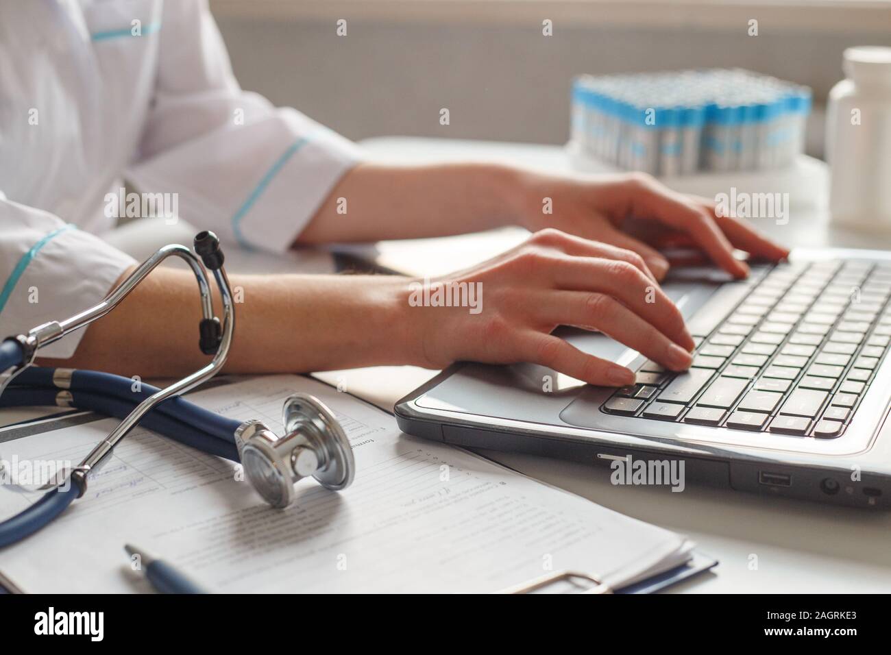 Femme médecin diagnosticien sur son lieu de travail à l'hôpital. Fonctionne sur un ordinateur portable avec x-ray et tests médicaux. Banque D'Images