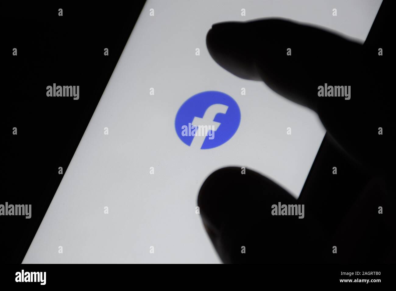 L'icône de Facebook sur l'écran du moniteur. Facebook L'un des plus gros réseau social. Icon Facebook.com. L'application de médias sociaux. Réseau social, avec le doigt Banque D'Images