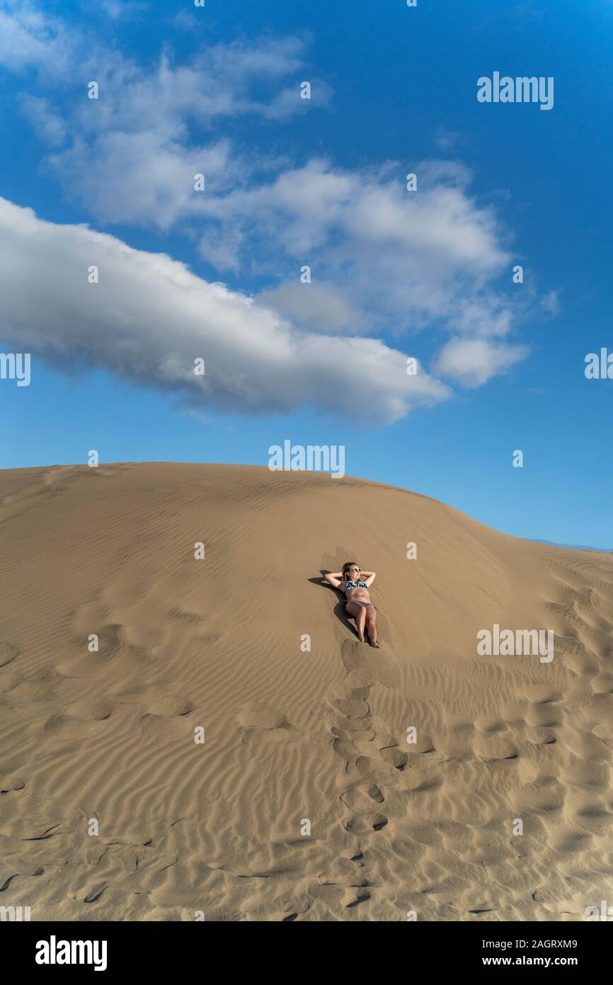 Les touristes appréciant les bains de soleil sur les dunes de Maspalomas, à Gran Canaria, Espagne Banque D'Images