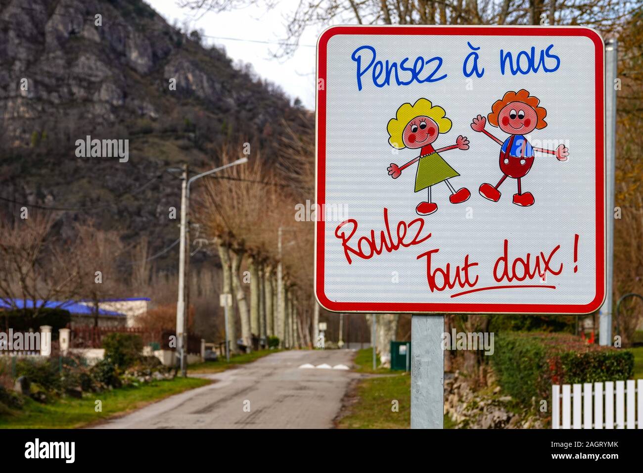 Panneau d'avertissement à French Village 'pensent de nous - ralentir' enfants jouant Banque D'Images