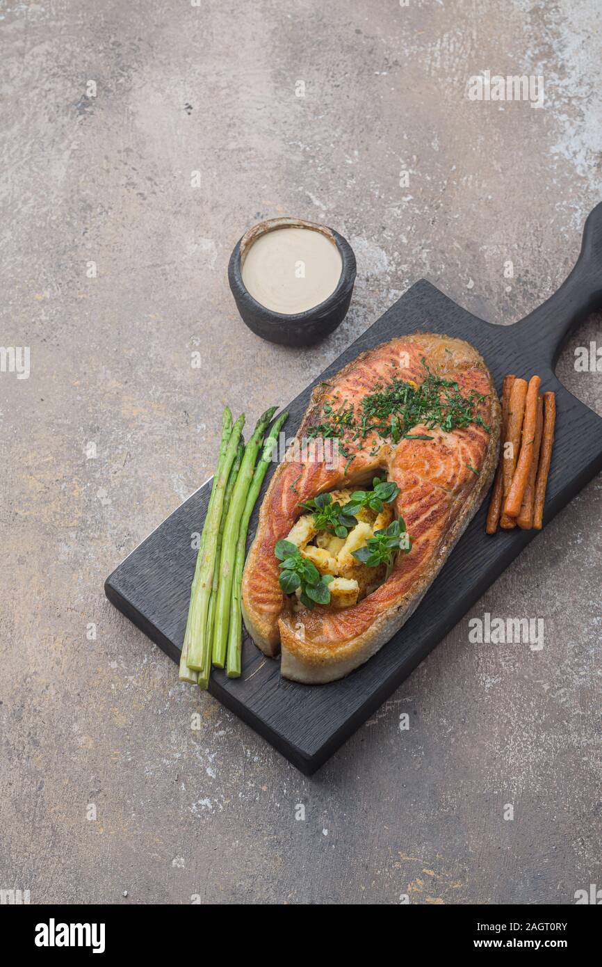 Pavé de saumon poêlé avec de la polenta sur planche de bois, copy space Banque D'Images