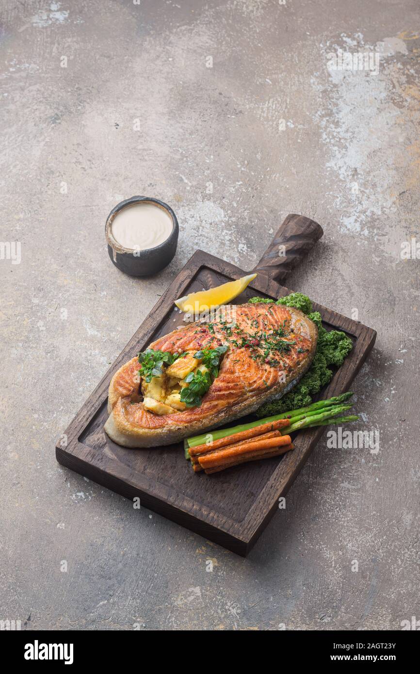 Pavé de saumon aux légumes sur planche de bois, copy space Banque D'Images