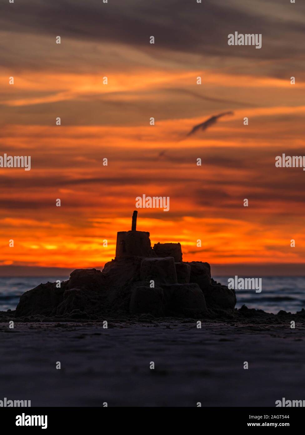 Coucher de soleil coloré dans l'océan derrière la silhouette d'un château de sable sur une plage dans le nord de la France Banque D'Images
