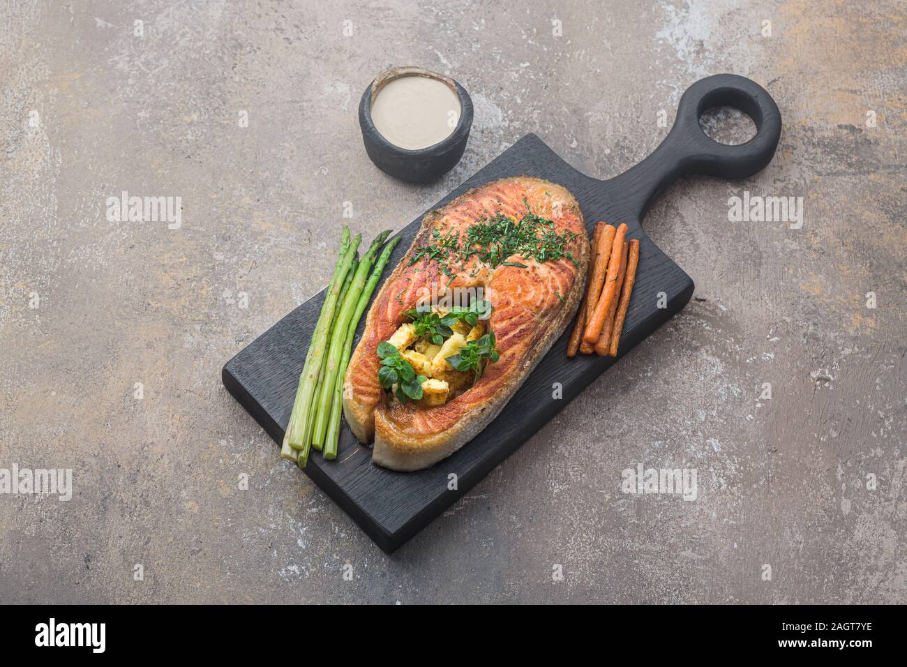 Pavé de saumon poêlé avec de la polenta sur planche de bois, copy space Banque D'Images