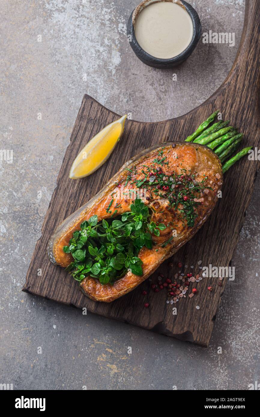 Pavé de saumon poêlé aux asperges sur planche de bois, copy space Banque D'Images