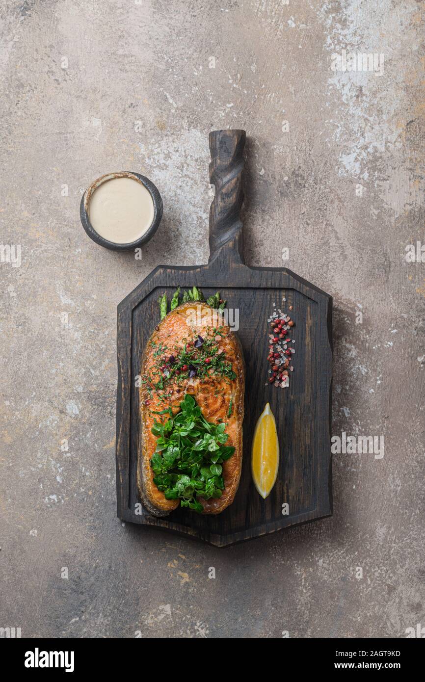 Pavé de saumon poêlé avec des légumes sur planche de bois, copy space Banque D'Images