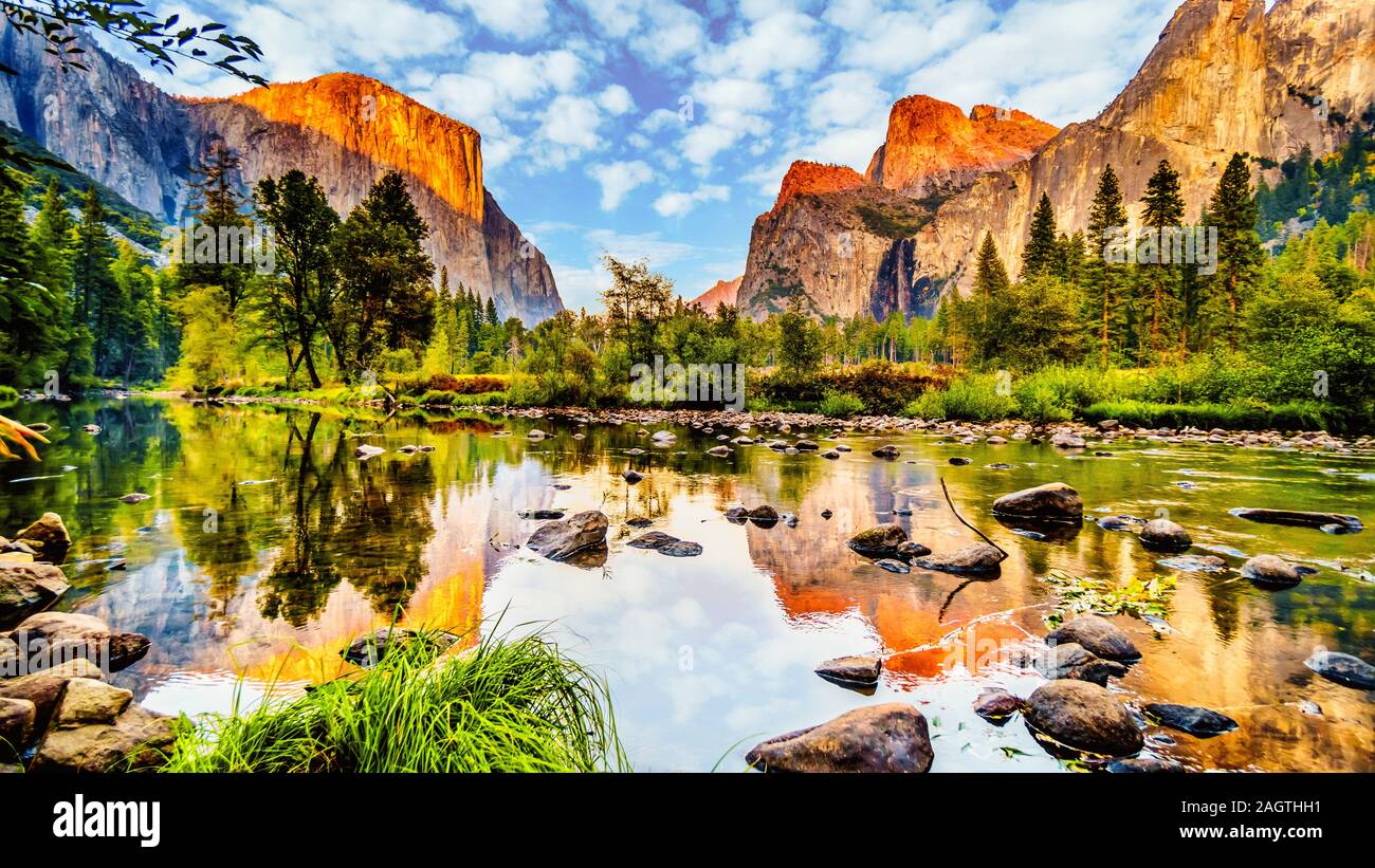 Coucher du soleil au-dessus des bougies de El Capitan sur la gauche et de la Cathédrale des rochers, Sentinel Rock et Bridalveil Fall sur la droite et se reflétant dans la rivière Merced, CA Banque D'Images