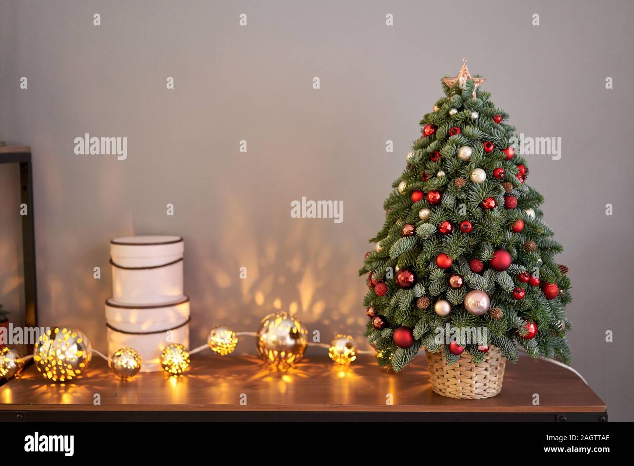 Magnifique petit arbre de Noël sur la table en bois. Bonne humeur. Lampe  guirlande sur bokeh background. Fond d'écran. Sapin et pin danois, Nobilis  Photo Stock - Alamy