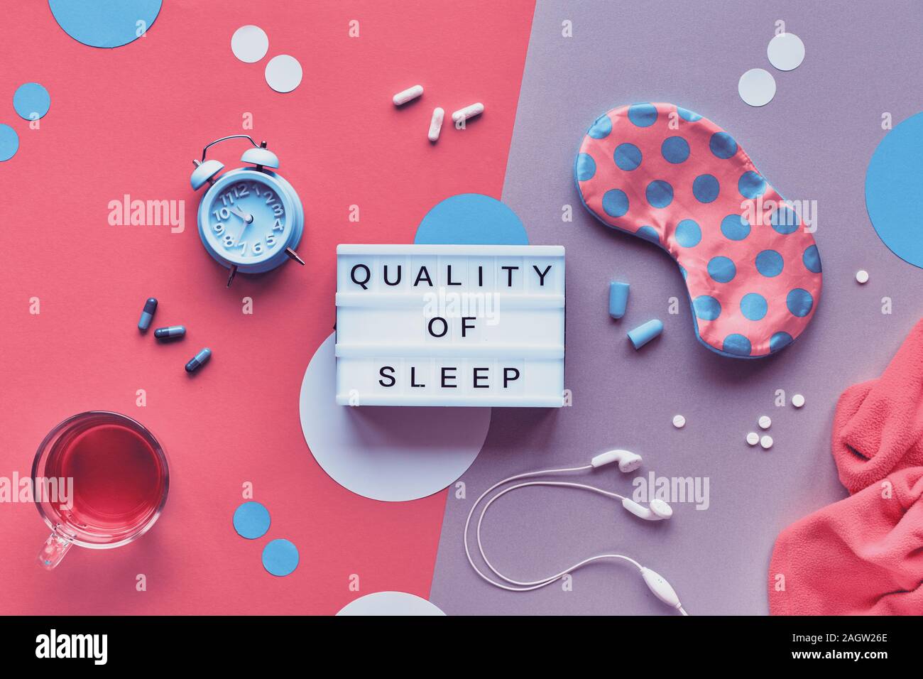 Nuit de sommeil sain concept créatif. Masque de sommeil, menthe bleue, alarme, bouchons d'écouteurs. Deux tons rose et fond argenté avec des cercles de papier. Fla Banque D'Images