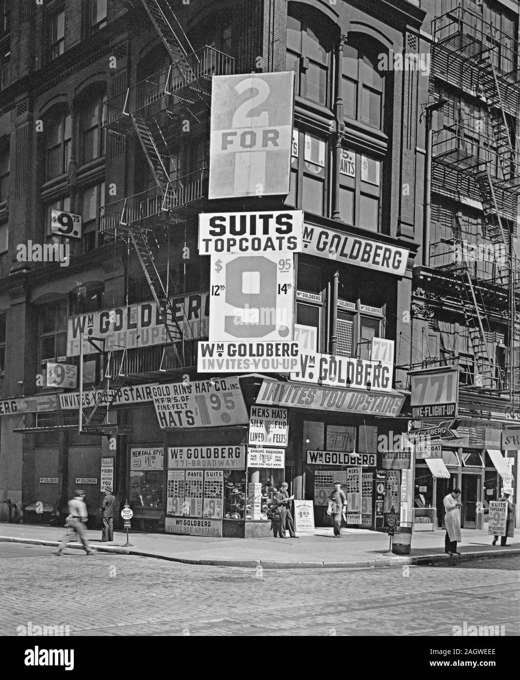 Signes couvrent trois histoires de Wm. Goldberg's Men's Clothing Store, l'homme en bas à droite annonce aussi par panneau ; autres piétons Banque D'Images