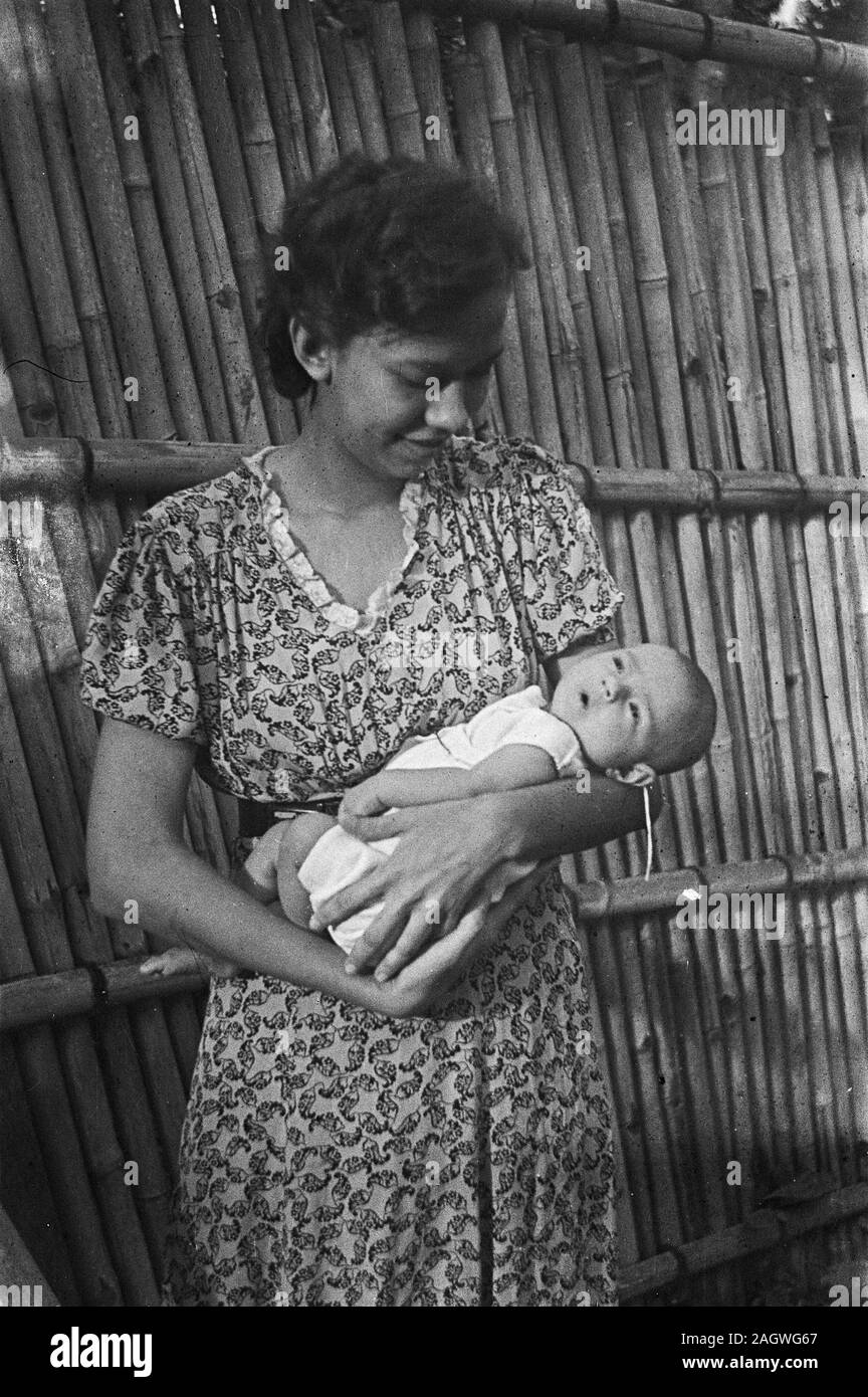 Femme indonésienne est titulaire ca bébé. 1947 Banque D'Images